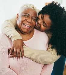 senior lady and her daughter laugh and hug together