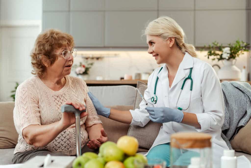 Home health care Pittsburgh PA: Doctor with syringe visiting elderly patient at home.