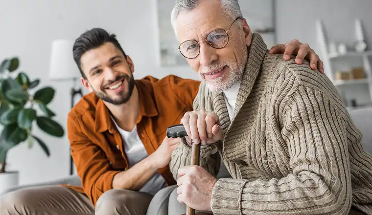 Senior man with cane and caregiver smiling. Home care in Bucks County.