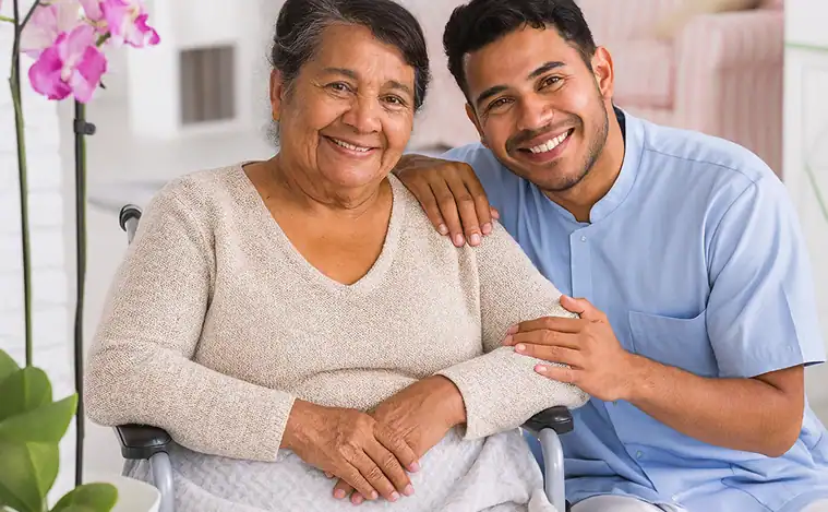 Smiling elderly woman in wheelchair with male caregiver, providing elderly care services.